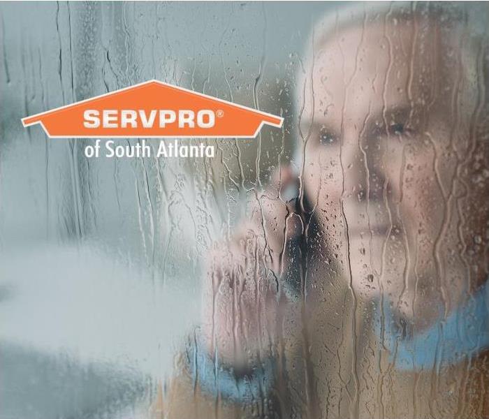 Man on phone inside window in a storm