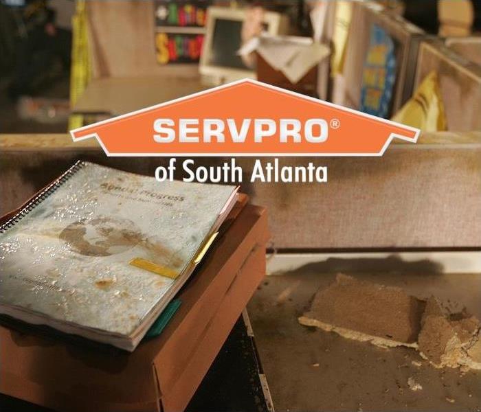a workspace and cubicle showing signs of water damage with SERVPRO of South Atlanta logo
